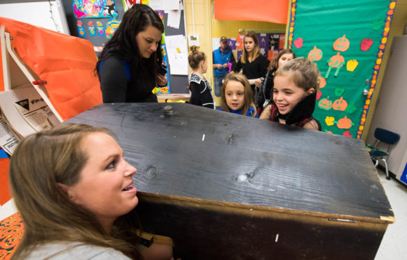 Heather Varner, left, uses her hand to scare students as they reach into a coffin fo a prize during the Northside Elementary Fall Festival. Photo by Bobby Ellis, Oct. 27, 2017