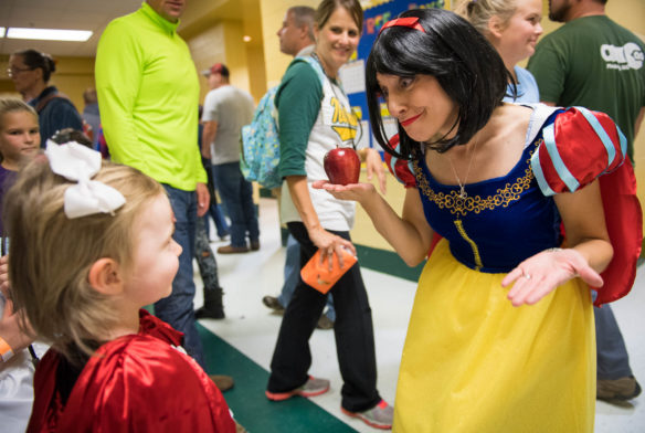 Kelly Sanders, right, a 1st-grade teacher at Northside Elementary shrugs her shoulders as she is asked by preschooler London Sherrad why she hasn't eaten her apple at the Northside Fall Festival. Photo by Bobby Ellis, Oct. 27, 2017