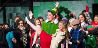 Buddy the Elf, Holden Stamper, lifts Jovie, Anna Story, into the air during the closing number of "Elf the Musical Jr." Photo by Bobby Ellis, Dec. 8, 2017