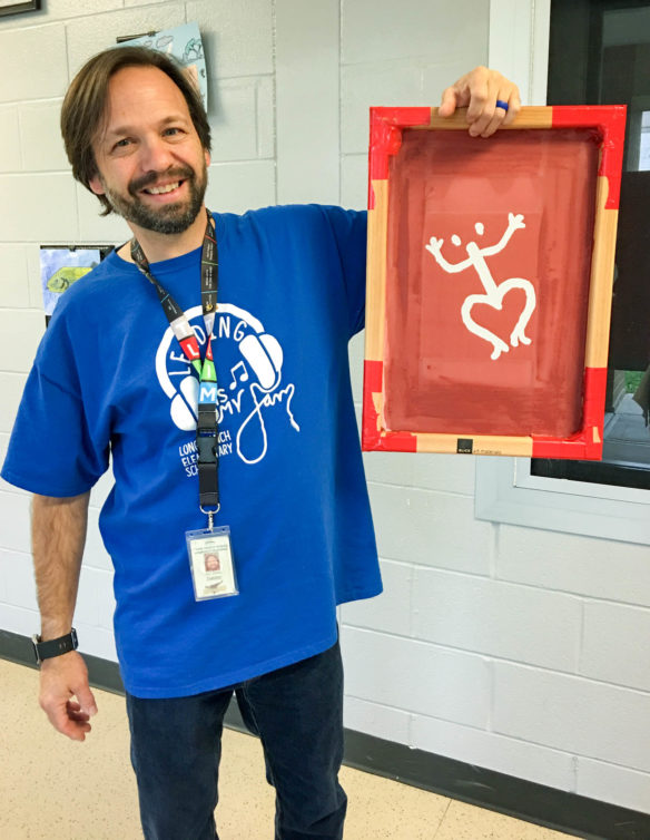 Jack Steele, visual arts teacher from Longbranch Elementary School (Boone County), shows one of the Taíno petroglyph models the school used for tie-dye T-shirts. Longbranch did a project-based learning activity in October, culminating in an event on Nov. 14 that raised $2,500 to directly aide Colegio Nuestra Señora de Valvanera in Coamo, Puerto Rico. Photo by Nitza Fernandez-Plaski