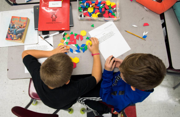 Fourth-graders Cruz King, left, and Eli McGuffey use tiles to work out a word problem in Crystin Moore's math class at Junction City Elementary (Boyle County). Moore is using inquiry-based lessons as part of pilot program to spread inquiry-based learning to more subjects. Photo by Bobby Ellis, Nov. 30, 2017