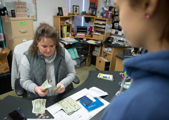Amber Florence, a business teacher at Harrison County Area Technology Center, counts out money as sophomore Morgan Nickerson pays back a loan she received in Florence's entrepreneurship class. Florence has retooled the school's business program, which was in danger of being dropped due to low enrollment before she was hired in 2016. Photo by Bobby Ellis, Dec. 5, 2017