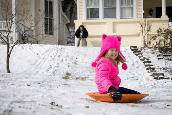 Ella Simpson rides a sled down a hill near her house after getting a push from her mom, Cathy Lindsey. Photo by Bobby Ellis, Jan. 13, 2018
