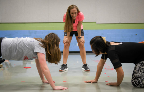 PE teacher Angela Stark, watches as Marianne Gebb, left, and Sofia Wu attempt to play plank hockey by sliding a bean bag between each other's arms during Stark's class at the School for the Creative and Performing Arts (Fayette County.) Stark is a finalist for National Middle School Teacher of the Year. Photo by Bobby Ellis, Jan. 29, 2018