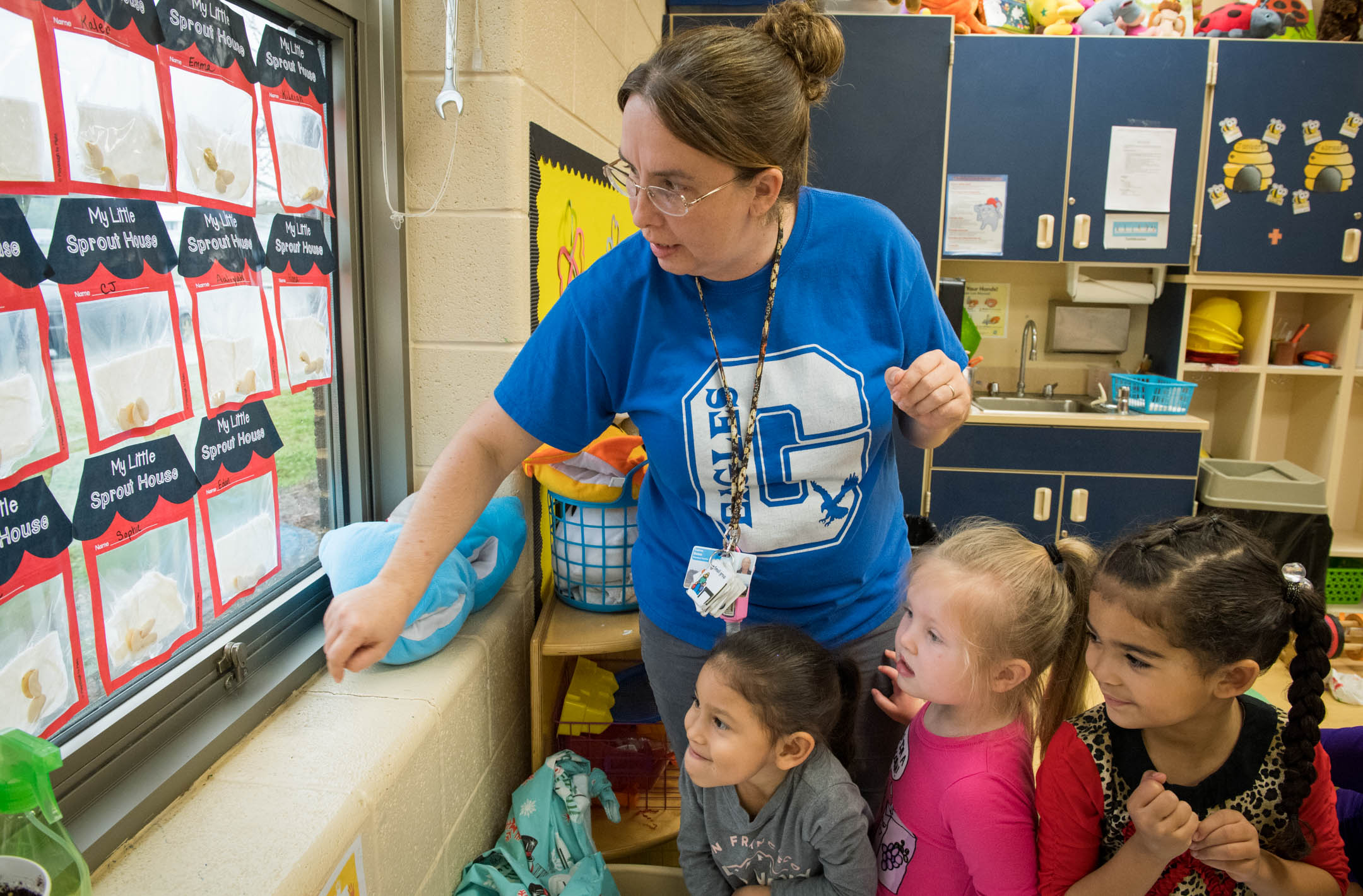 Daphne Boles, a pre-school teacher at Graves Central Elementary, looks at a seed growing experiment with Dahlia Ruelas, Alana Hearson and Sophie Williams in Boles' pre-schoool class. Photo by Bobby Ellis, March 28, 2018