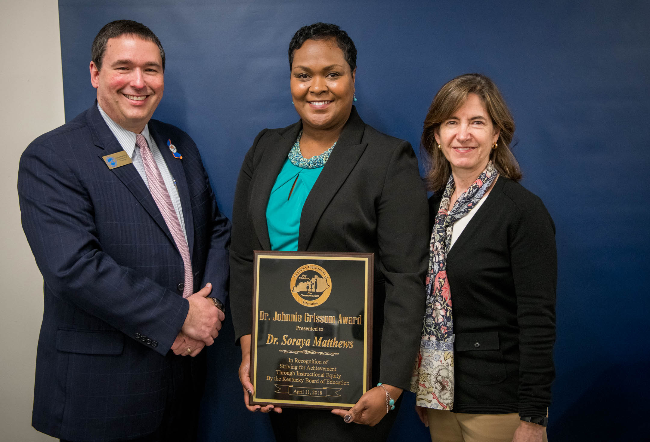 Soraya Matthews, center, poses with Commissioner Stephen Pruitt and KBE Chair Mary Gwen Wheeler after being awarded the Dr. Johnnie Grissom Award. Photo by Bobby Ellis, April 11, 2018