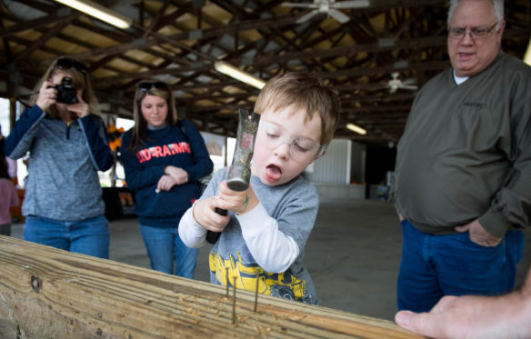 Hunter McIntosh attempts to hammer nails during the Big Dig event at the Boone County Fair Grounds. Photo by Bobby Ellis, April 21, 2018