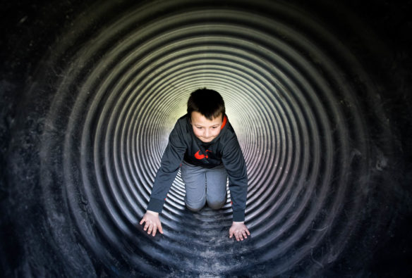 Logan Branch crawls through a pipe while attending the Big Dig event at the Boone County Fair Grounds. Photo by Bobby Ellis, April 21, 2018