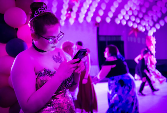 Alexis Stanton, a senior at Franklin County High School, checks her phone before getting on the dance floor. Photo by Bobby Ellis, May 12, 2018