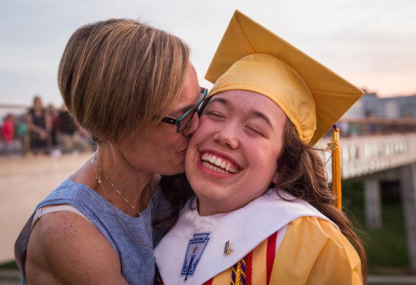 Sarah Moser, right, gets a kiss from her mother, Jennifer Moser, after graduation from Campbell County High School. Photo by Bobby Ellis, June 4, 2018