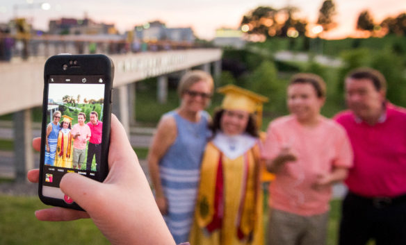 Elyse Thaman takes a picture of the Moser family after the Campbell County High School graduation ceremony. Photo by Bobby Ellis, June 4, 2018