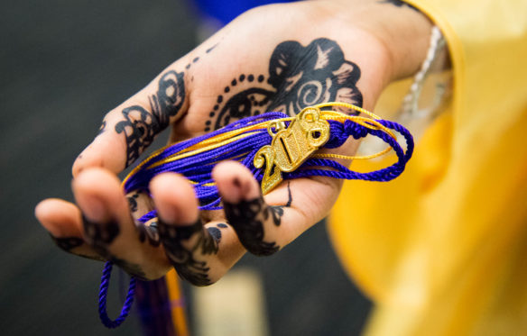 Kin Adan holds her tassel after the graduation ceremony. Photo by Bobby Ellis, June 4, 2018