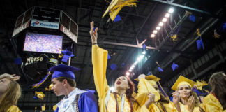 Jaclyn Fischesser, center, tosses her hat along with her classmates after graduation from Campbell County High School. Photo by Bobby Ellis, June 4, 2018