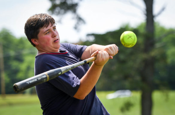 Joshua Smith, a student at Paris High School (Paris Independent), swings at a ball during the athletics period of the FFA camp. Photo by Bobby Ellis, June 12, 2018