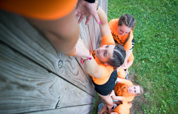 Allison Knott, of Apollo High School (Daviess County) gets help from her teammates as she is pulled up a scaling wall. Photo by Bobby Ellis, June 12, 2018