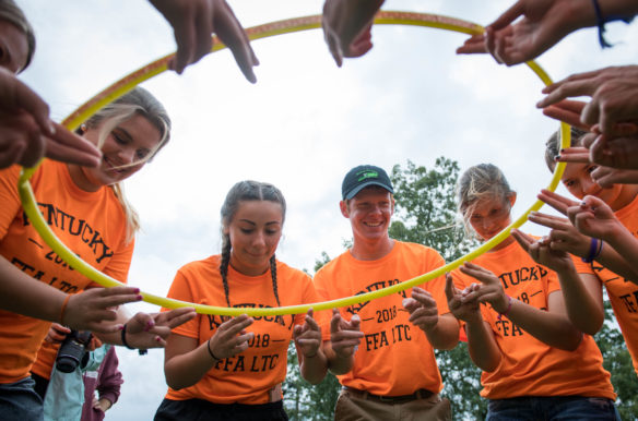 Members of the Apollo FFA chapter work together to try to lower a hula hoop onto the ground as part of a team building exercise. Photo by Bobby Ellis, June 12, 2018