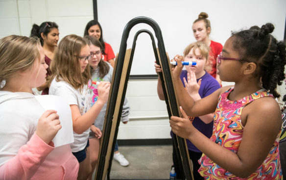 Two teams of girls attempt to draw a food web the fastest during the STEM You Can! camp. Photo by Bobby Ellis, June 13, 2018