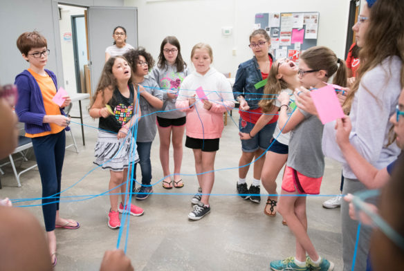 STEM You Can! camp goers use yarn to create a food web after choosing labels of either producers or consumers. Photo by Bobby Ellis, June 13, 2018