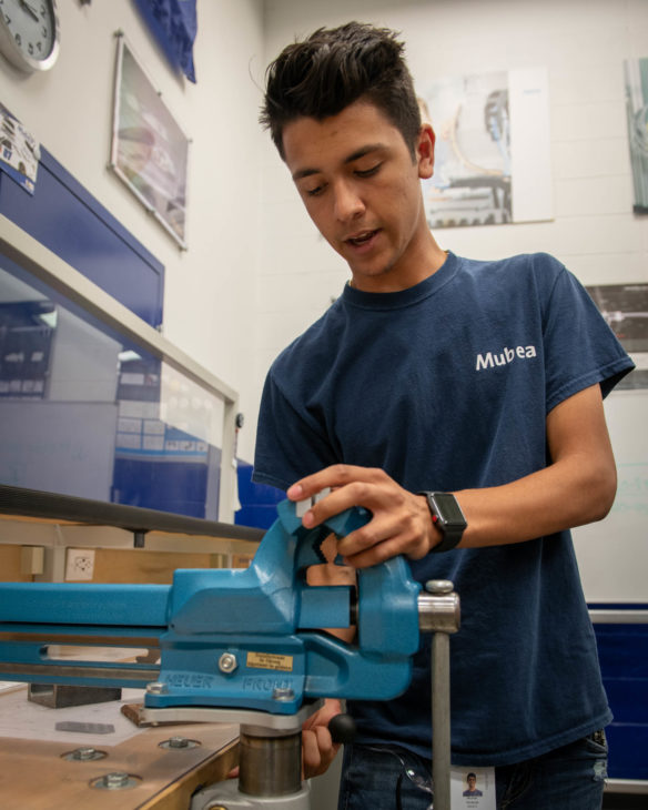 Michah Schenck, an apprentice with Mubea Inc. in Florence, demonstrates how to properly use a vise in Mubea's apprentice training center. Schenck spent part of his senior year in high school with the automotive products manufacturing company as part of the Tech Ready Apprentices for Careers in Kentucky (TRACK) youth pre-apprenticeship program. Photo by Bobby Ellis, July 18, 2018