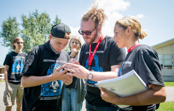 Jesse Hairston, a research scientist at the University of Alabama in Huntsville, helps students taking part in a scavenger hunt at a cybersecurity camp for deaf and hard-of-hearing students at Kentucky School for the Deaf. Photo by Bobby Ellis, July 25, 2018