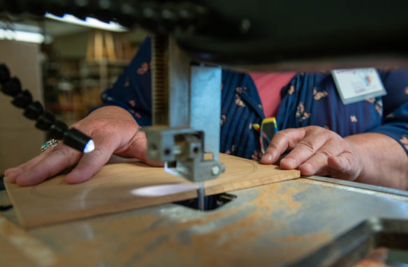 Shelley Mosier, a teacher at Henry Clay High School (Fayette County) uses a bandsaw to cut a piece of a nesting gift box in one of the woodworking classes at the Festival of Learnshops. Photo by Bobby Ellis, July 19, 2018