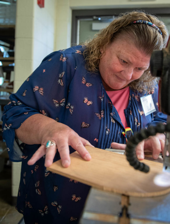 Shelley Mosier, a teacher at Henry Clay High School (Fayette County) uses a bandsaw to cut a piece of a nesting gift box in one of the woodworking classes at the Festival of Learnshops at Berea. Photo by Bobby Ellis, July 19, 2018