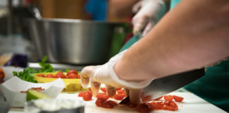 Cherry tomatoes are chopped up during the lab portion of a hands on summer training session for school nutrition professionals put on by the Kentucky of Education in partnership with the Institute of Child Nutrition at Henry County Middle School. Photo by Bobby Ellis, Aug. 1, 2018