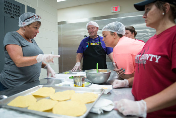 School nutrition professionals work on making Eagle Pizza, a pizza made with meat alternatives during the nutritional training lab. Photo by Bobby Ellis, Aug. 1, 2018