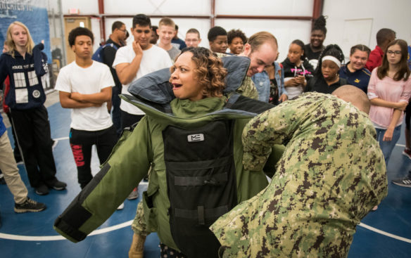 Kymberly Rice, principal of the Academy at Shawnee is helped into a bomb disposal suit. Photo by Bobby Ellis, Aug. 23, 2018