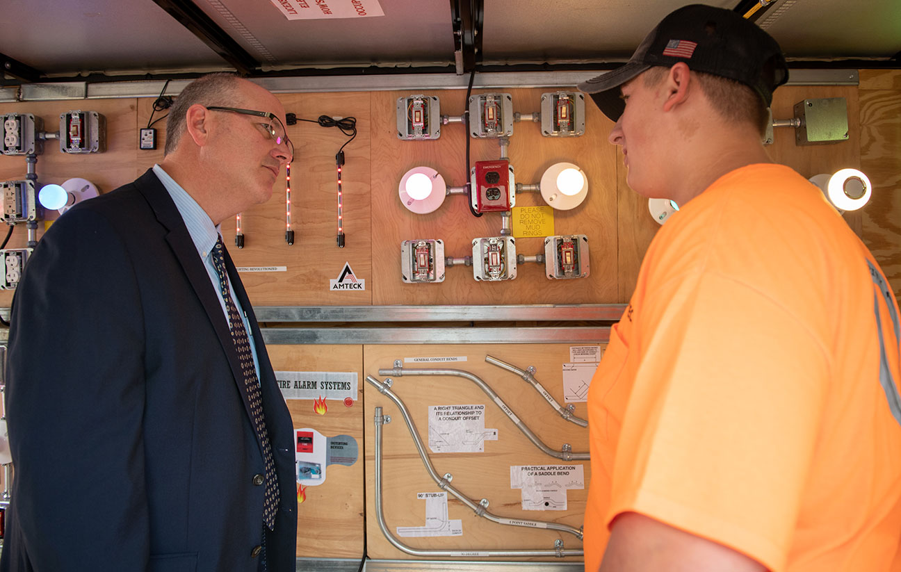 Scott Stump, assistant secretary of the United States Department of Education, left, talks with Aaron Sturgill, a senior at East Jessamine High School (Jessamine County), on board an educational bus used by AMTECK at its apprenticeship training facility in Lexington. Photo by Bobby Ellis, Sept. 12, 2018