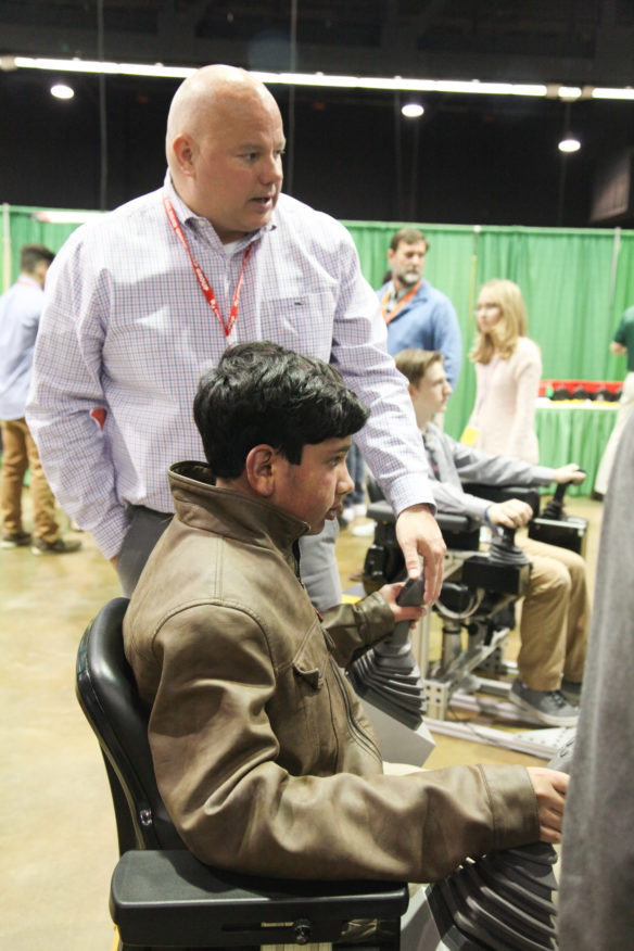 Achiles Moraitis of Frederick Douglass High School got some tips on how to operate a virtual excavator during the 2nd annual Academies of Lexington Career Expo. Photo by Megan Gross, Nov. 5, 2018