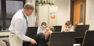 David Sandlin makes a point to student Cameryn McPherson during Sandlin’s financial literacy class at Walton-Verona High School (Walton-Verona Independent). Sandlin, who worked as an investment consultant prior to becoming a teacher, will serve on both a business and education advisory panel and a standards revision and writing committee during the process of developing financial literacy standards. Photo by Megan Gross, Nov. 19, 2018