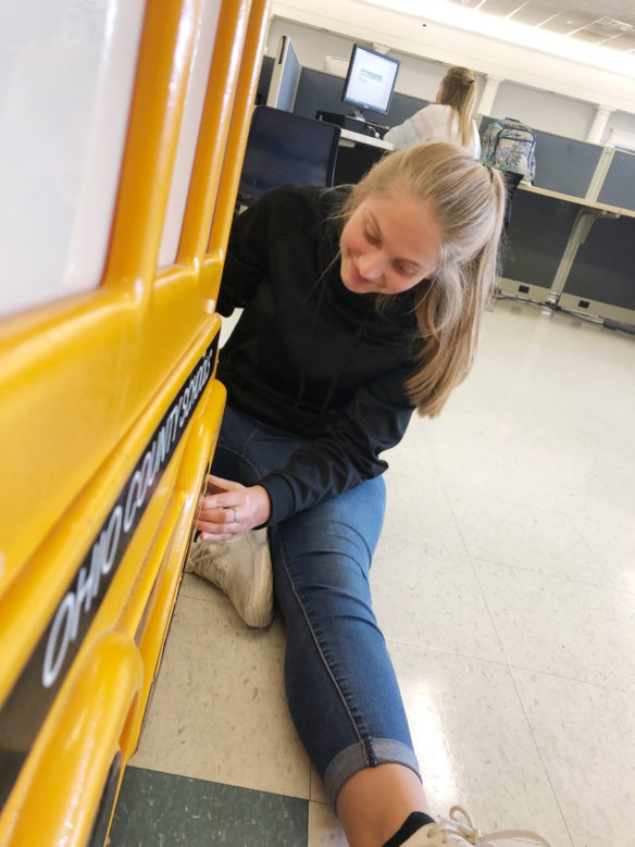 Winter Smith, a student at Ohio County High School, gives the district's aging Buster the School Bus a face-lift with new stripe. Students in several of Brian Barrett's classes used the district's broken Buster to get hands-on experience repairing older technology. As the news of the bus rebuild has grown, two more broken Busters have been added to the classroom inventory for Barrett and his students to repair. Submitted photo by the Ohio County High School yearbook staff