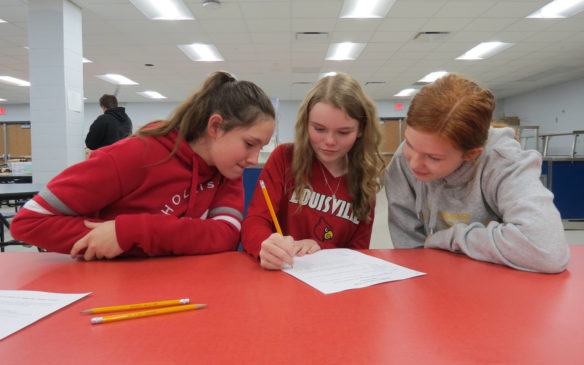 Discovery School students, from left, Ashlee Blair, Allyson Morgan and Kaytlyn Coleman work on their Engineering Design Project narrative at Bullitt County's annual STEM competition for middle and high school students. Photo submitted