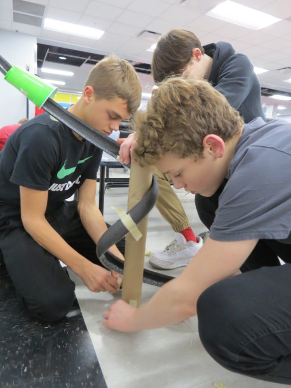 Hebron Middle School (Bullitt County) students, from left, Ryan Still, Zach Pine and Conner Boley work on the curves of their roller coaster during a STEM competition for middle and high school students in Bullitt County. Photo submitted