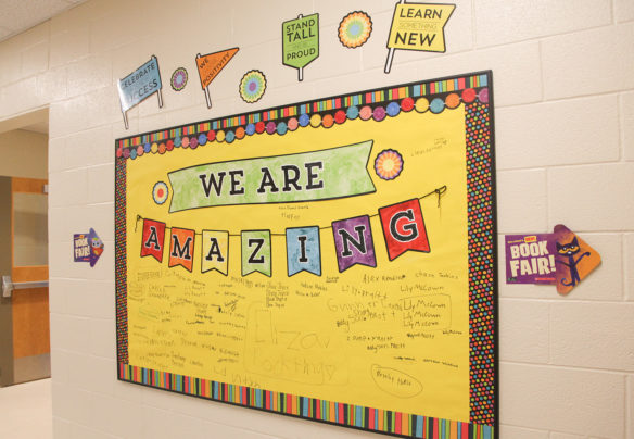A bulletin board in the hallway at Spottsville Elementary School bears students’ signatures. Photo by Megan Gross, March 20, 2019