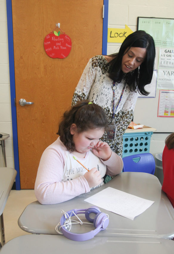 Sarah Estabrook, the principal at Spottsville Elementary School, looks over the work of student Lucy Williams. Photo by Megan Gross, March 20, 2019
