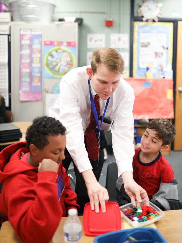 Maxwell Elementary Principal Robert Crawford, center, assists Darius Surratt, left, and Felipe Moreira with a game in their mathematics class. 