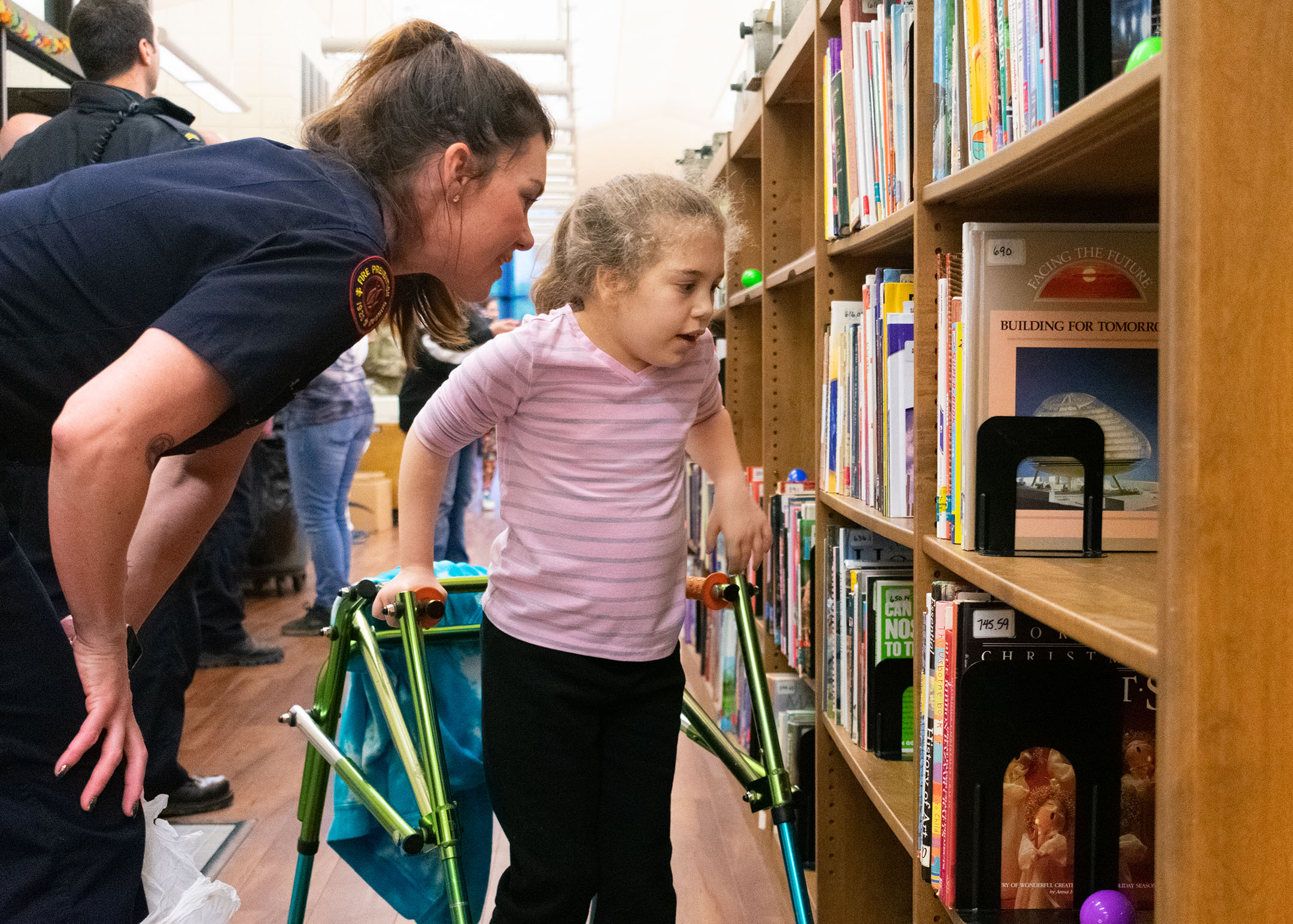 A first responder leans in to help Ady Hulett search for eggs in the KSB library during the accessible Easter egg hunt. First responders from Louisville and Fort Knox assisted the students in their search for accessible Easter eggs. Photo by Jacob Perkins, April 19, 2019
