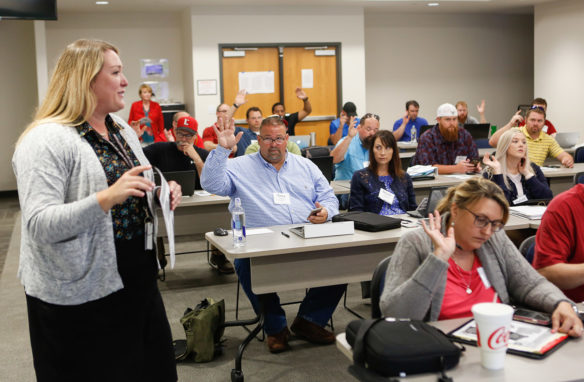 Tony Rutledge, center, a construction teacher at Henderson County High School, raises his hand along with others in response to a question by Brittney Howell, director of district student services for Frankfort Independent schools, at a New Teacher Institute (NTI) training session on diverse learners at the Kentucky Department of Education offices in Frankfort. Photo by Mike Marsee, June 10, 2019