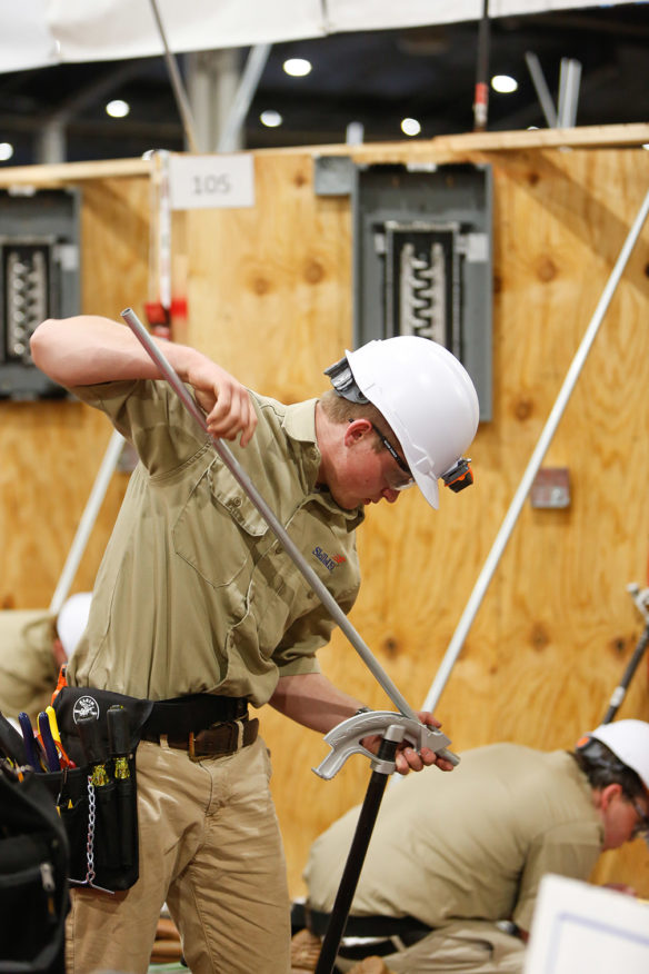 Bryson Scudder, a student at Boone County Area Technology Center, bends a piece of electrical conduit as he competes in the electrical construction wiring at the SkillsUSA Championships. Photo by Mike Marsee, June 26, 2019