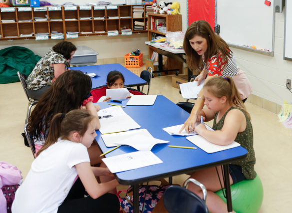 Brittany Sams, a 1st-grade teacher at Wyan-Pine Grove Elementary School works with students during an after-school learning session.