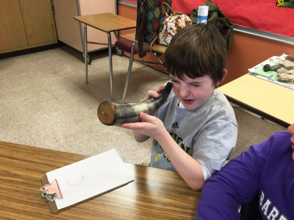A student examines an artifact during a History smArts classroom lesson.