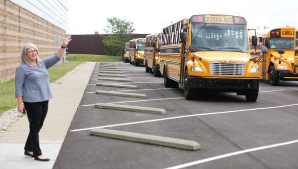 Julie Whitis, co-principal of Ignite Institute (Boone County), waves to students as they leave on buses at the end of the school day. Photo by Mike Marsee, Aug. 22, 2019