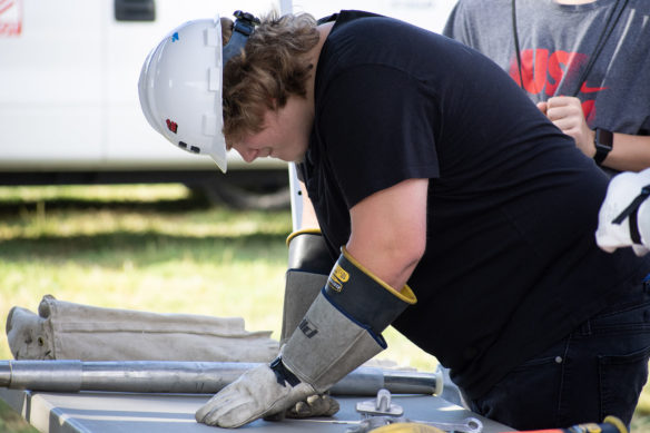 Dustin Dakin from Bullitt East High School tries his hand at picking objects up while wearing electrical grade gloves.