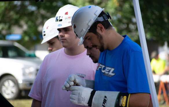 Caleb Heitzman from Bullitt East High School looks at an object he picked up using electrical grade gloves.