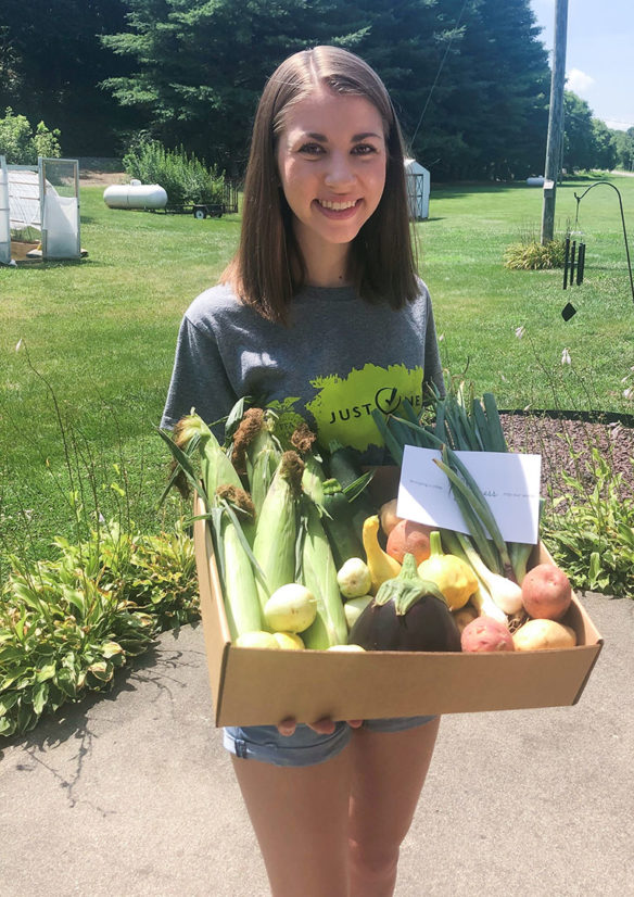 Olivia Moore poses with one of her produce boxes.