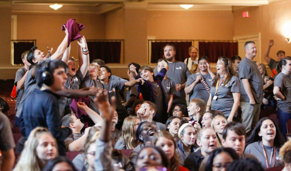 Aaron Meadows, center, a 7th- and 8th-grade history teacher at Paris Middle School (Paris Independent) watches as his students vie for T-shirts being thrown into the crowd at a kickoff celebration for GEAR UP Kentucky at Eastern Kentucky University in Richmond. Photo by Mike Marsee, Sept. 25, 2019