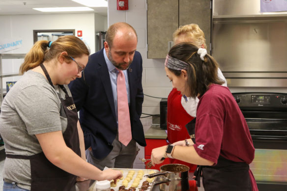 Fleming County High School culinary students show their treats to Superintendent Brian Creasman.