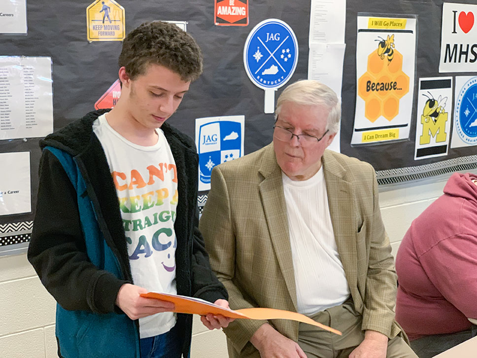 Chase Smith shares with Kentucky Board of Education member Mike Bowling one of the project-based learning activities that his team was working on as a capstone in the Jobs for America's Graduates program at Middlesboro High School (Middlesboro Independent).